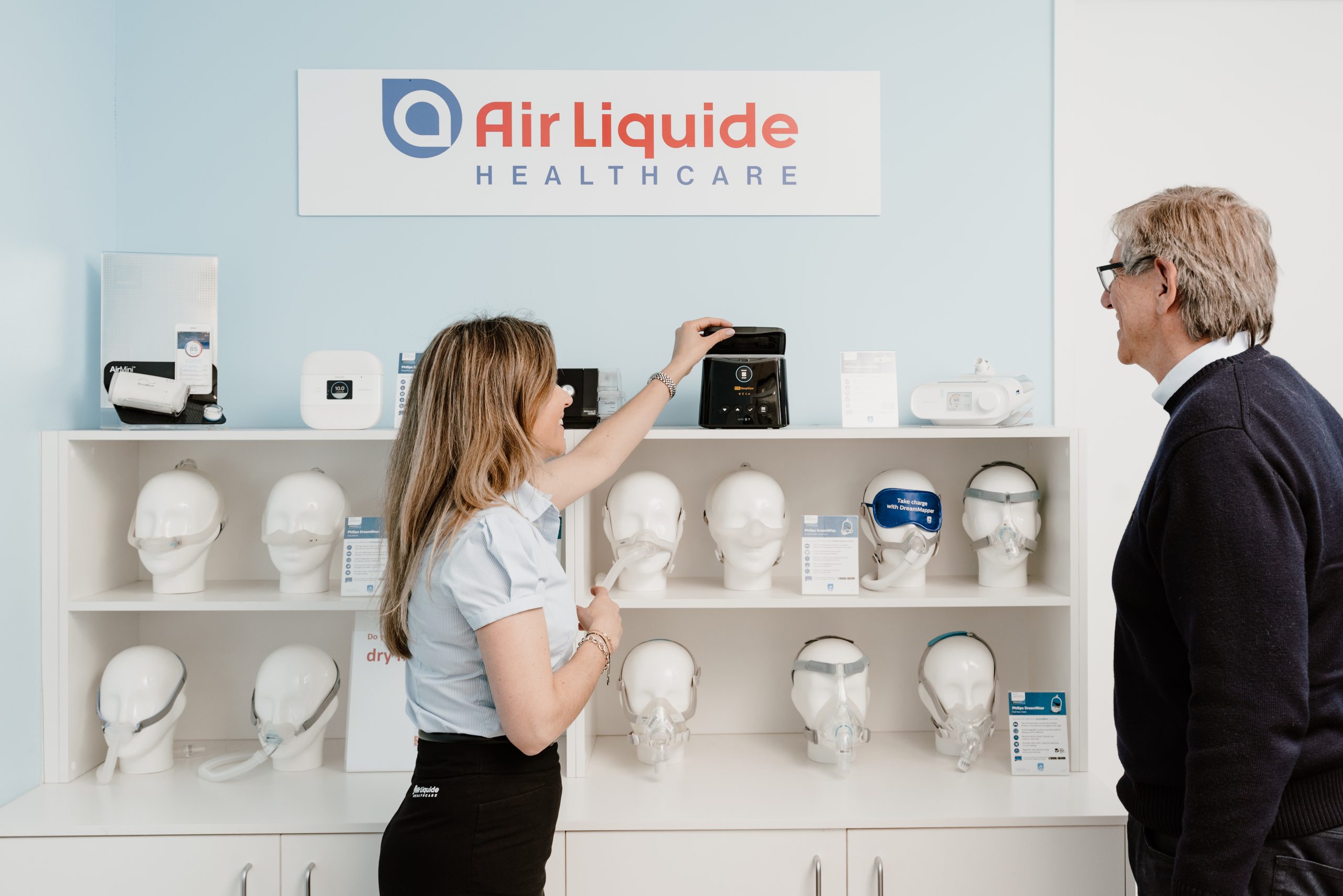 A sleep therapy consultant and a patient looking over the PAP machines on display in an Air Liquide Healthcare clinic